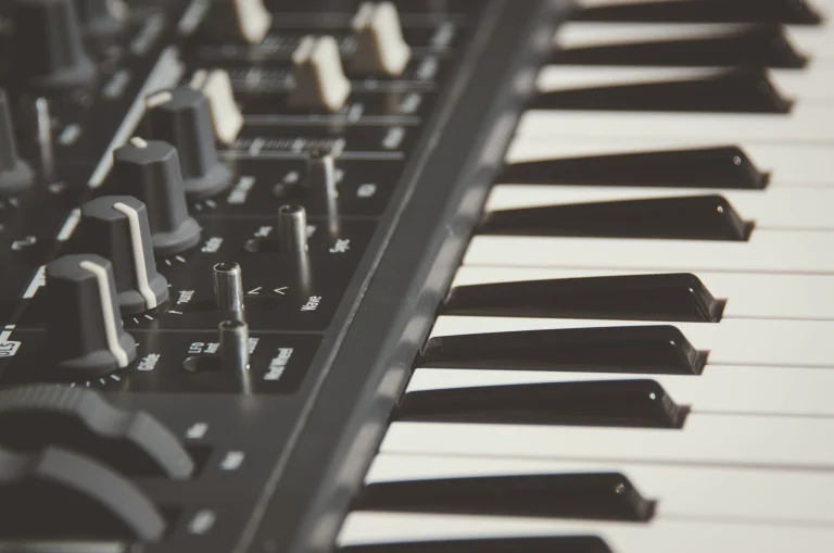 Detailed view of an electronic keyboard and its control knobs, highlighting modern musical equipment — an editorial image for "The Evolution of Electronic Dance Music."