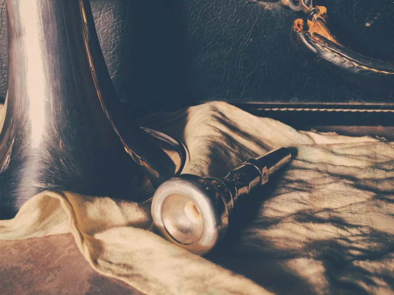 Artistic shot of a trumpet mouthpiece on fabric evokes a vintage musical feel — an editorial image for "How Jazz Changed the Sound of the Twentieth Century."