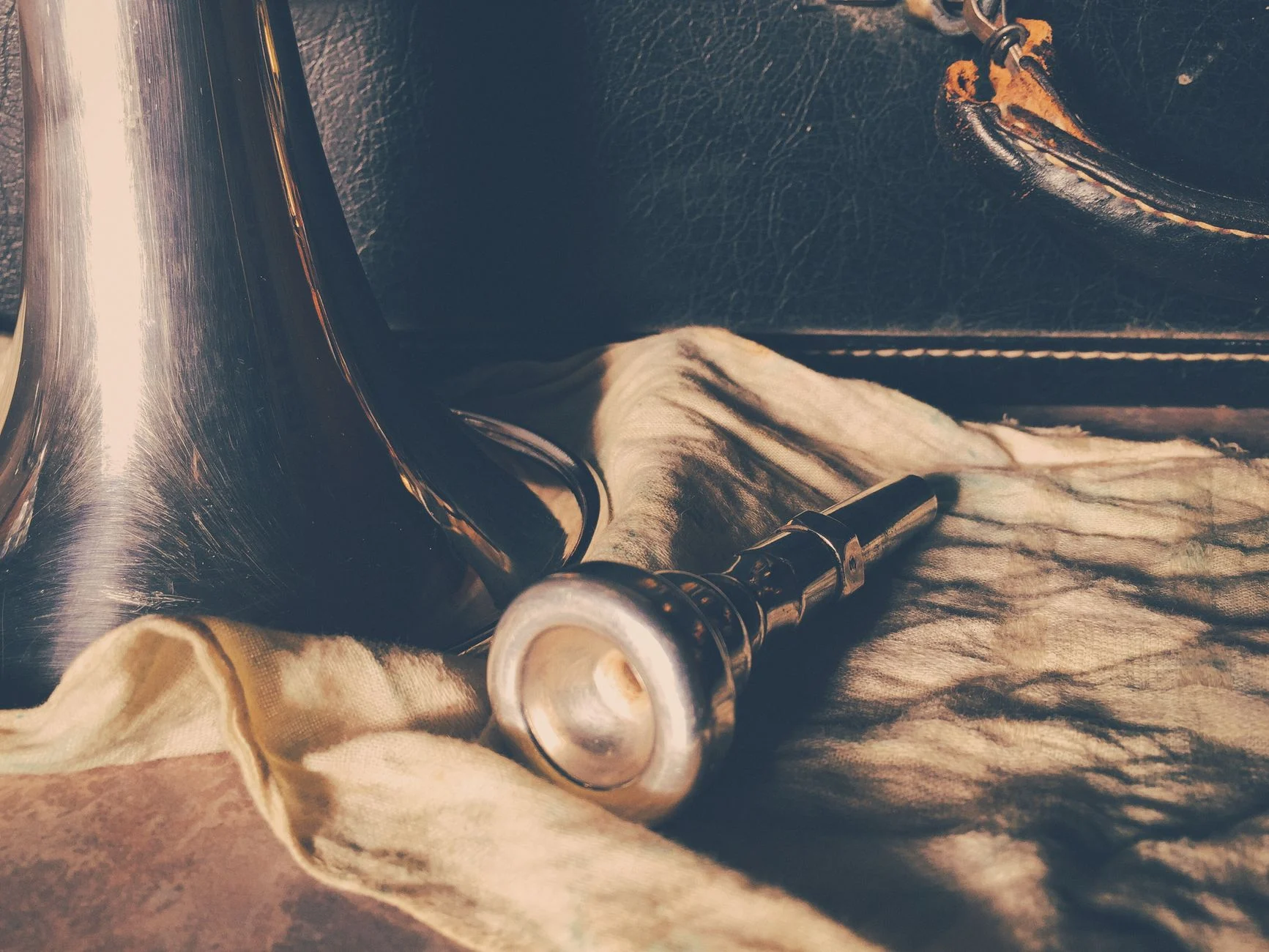 Artistic shot of a trumpet mouthpiece on fabric evokes a vintage musical feel — an editorial image for "How Jazz Changed the Sound of the Twentieth Century."