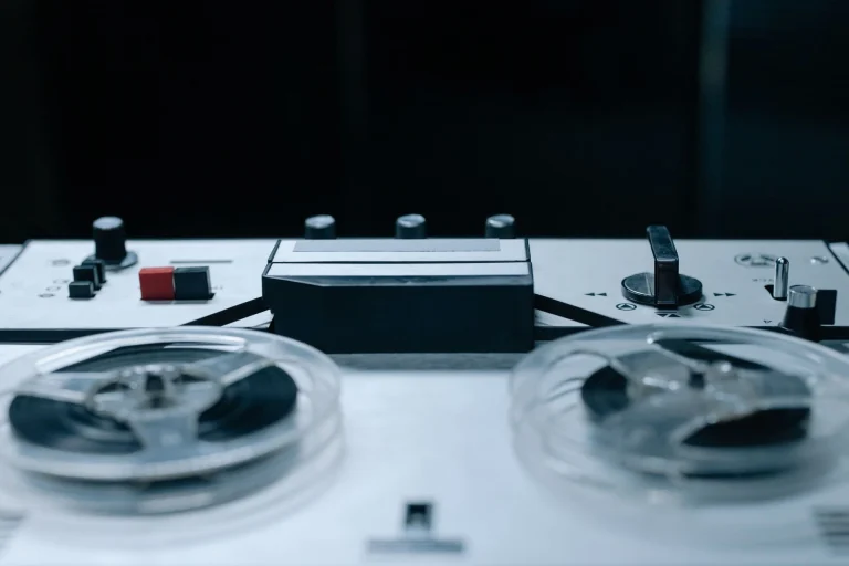 Close-up image of a vintage reel-to-reel audio recorder with control buttons and tape reels — an editorial image for "Like a Rolling Stone and the Expansion of the Pop Song."