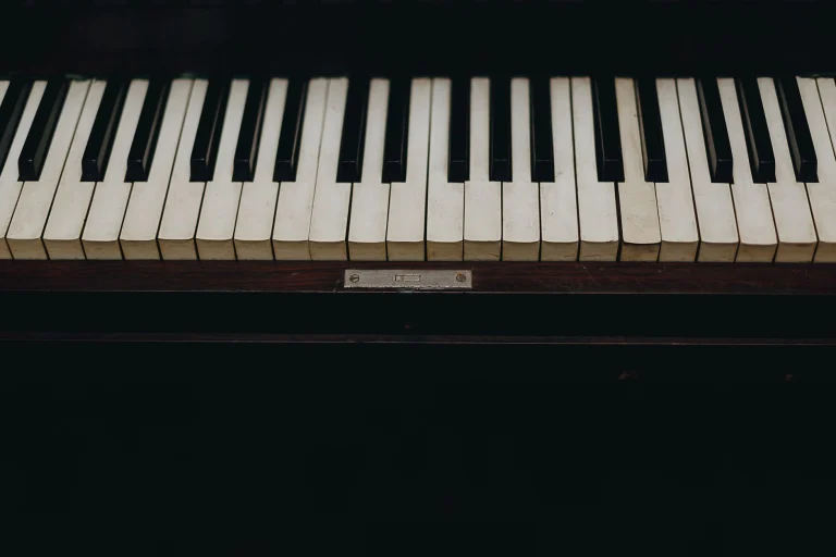 A close-up view of vintage piano keys showcasing the wear and character of the instrument — an editorial image for "Progressive Rock and the Album as Concept."