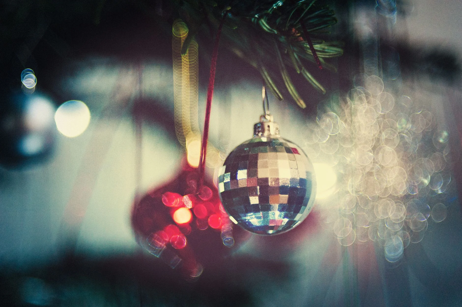 A close-up of sparkling Christmas ornaments on a tree with a beautiful bokeh background — an editorial image for "The Rise, Fall, and Lasting Influence of Disco."