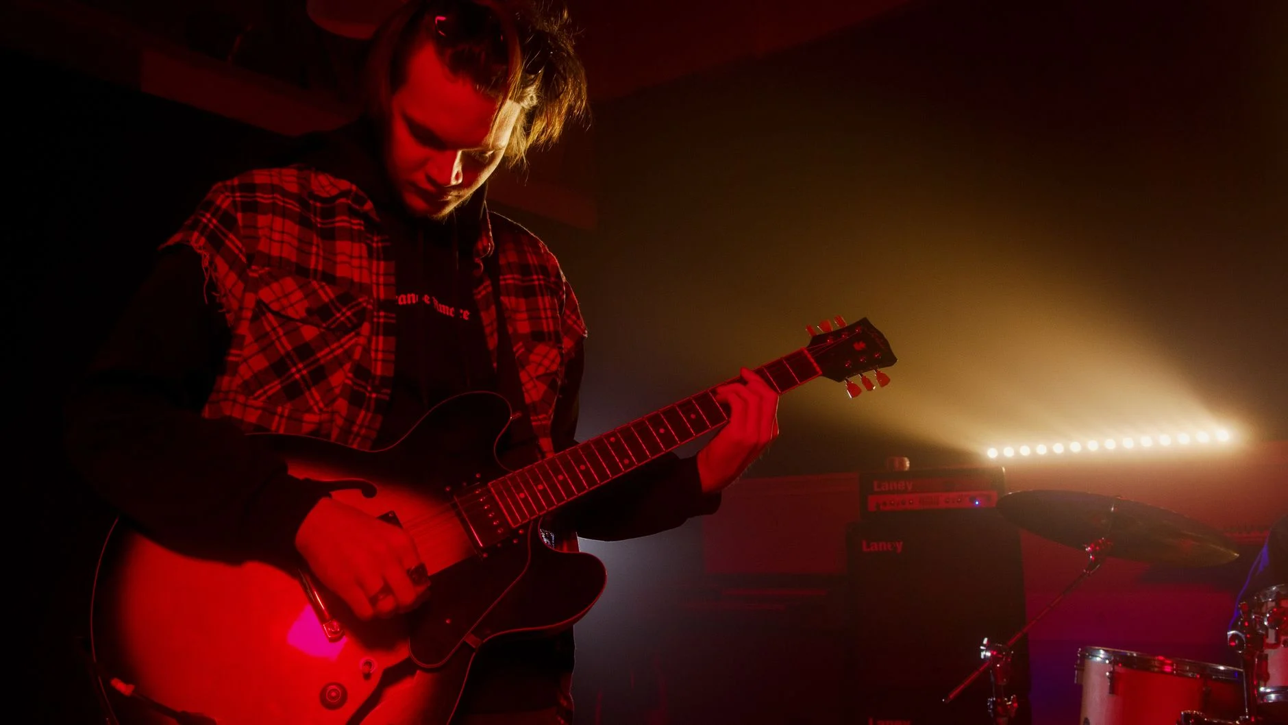 Guitarist playing electric guitar on stage with moody lighting — an editorial image for "Smells Like Teen Spirit and the Sound of a Generational Shift."