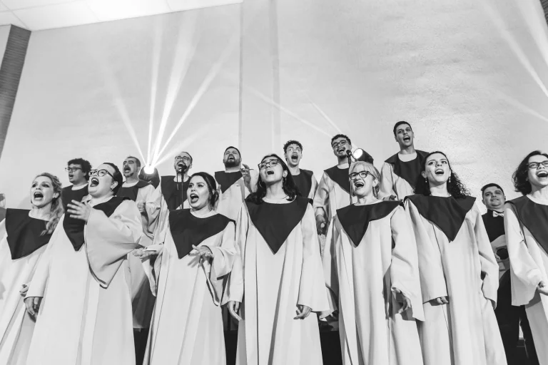 A vibrant choir passionately sings together, expressing harmony and joy in black and white — an editorial image for "Soul Music: Voices, Communities, and Cultural Influence."